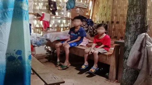 2 đứa trẻ co ro trong túp lều nát với tấm di ảnh mẹ